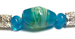 A core of CiM Adriatic with layers of clear and silver glass created this bicone focal bead. Spacers are pure Adriatic.