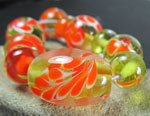 Messy Orange Crush over dots of Effetre white; core color is Effetre light olive